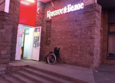 Инвалидное кресло стоящее на входе в магазин ''Красное и белое''.