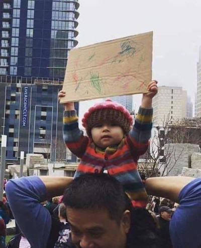 Ребёнок с детским плакатом на демонстрации.
