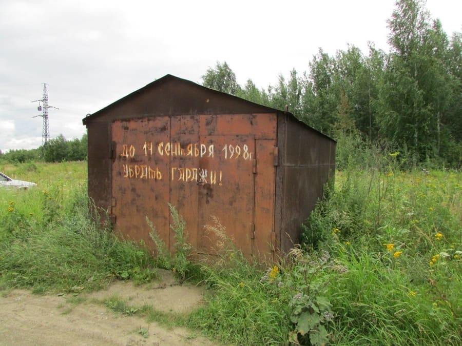Надпись на стареньком гараже: *До 14 сентября 1998 года убрать гаражи!*