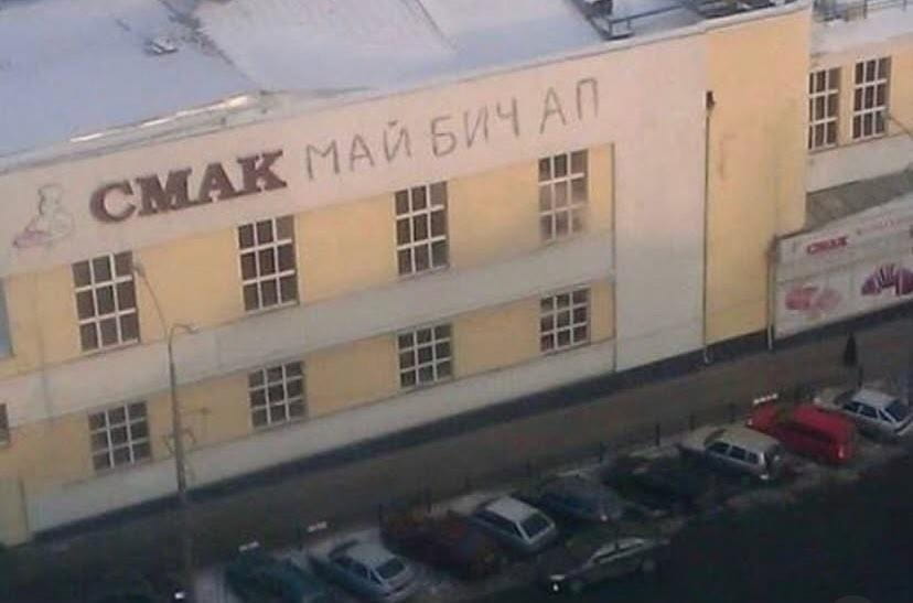 Надпись на доме: *СМАК МАЙ БИЧ АП!*